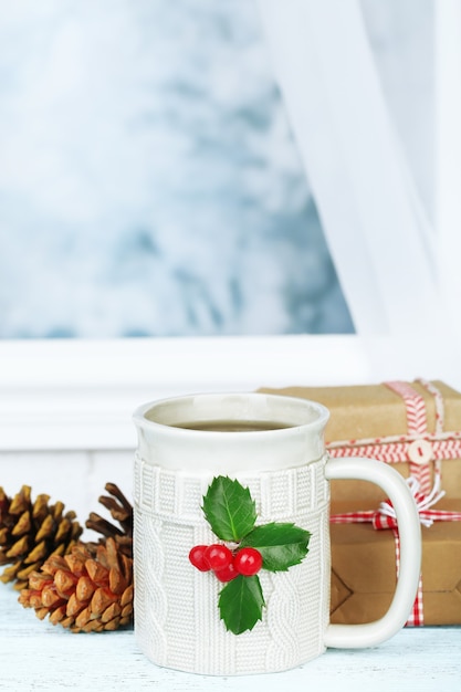 Composition de Noël avec tasse de boisson, sur table en bois