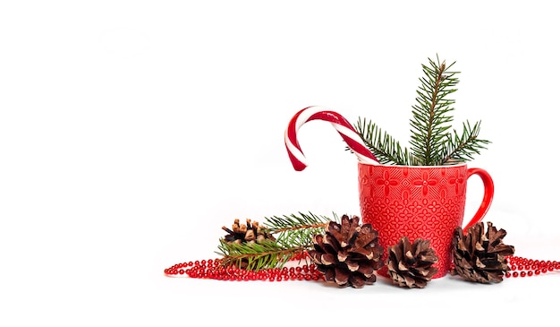 Composition de Noël avec tasse rouge, pommes de pin et aiguilles de sapin