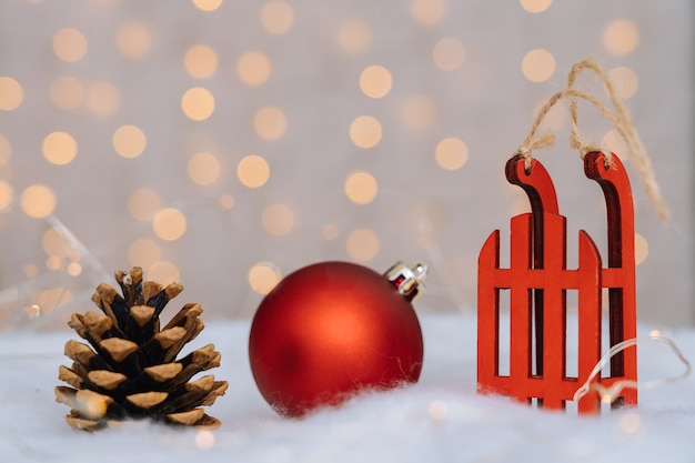 Composition de Noël avec traîneau de père Noël en bois rouge, pomme de pin et boule de Noël