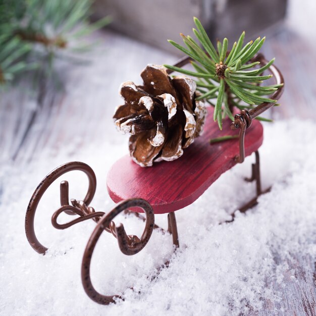 Composition de Noël avec traîneau, pomme de pin et décoration