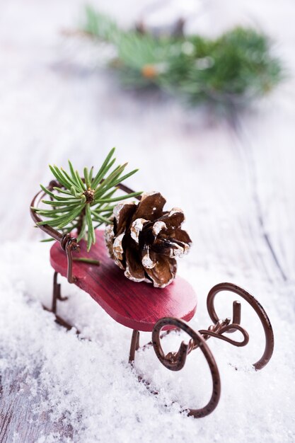 Composition de Noël avec traîneau, pomme de pin et décoration