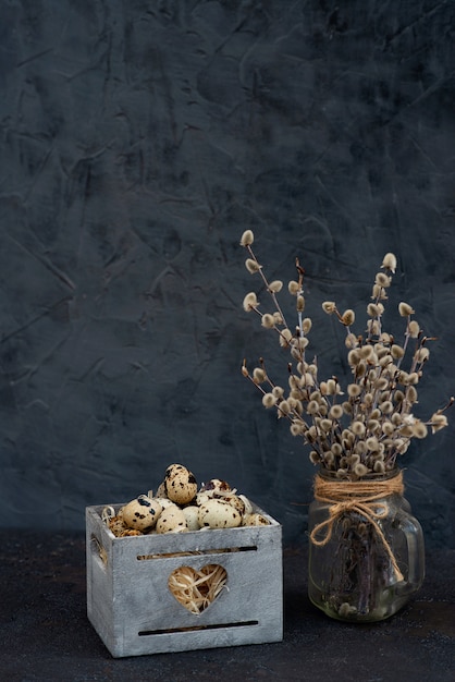 Composition d'oeufs de caille dans une boîte en bois de branches de saule dans un vase