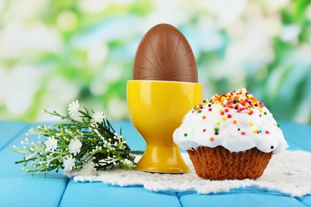 Photo composition d'œufs de pâques et de chocolat sur une table en bois sur fond naturel