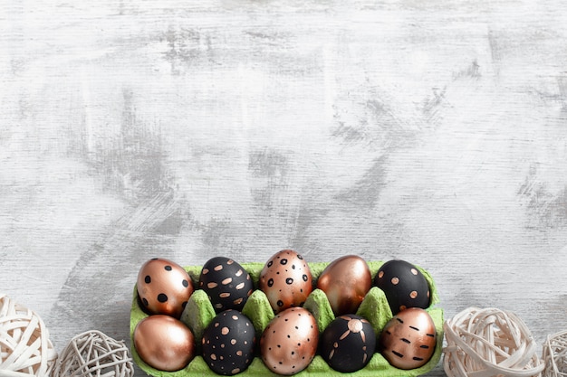 Composition Avec Des Oeufs De Pâques Peints En Or Et Noir Sur La Lumière.