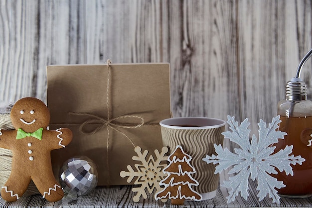 Composition d'ornements de Noël avec tasse à bulbe, tasse en carton, pain d'épice et présent Fond en bois avec espace de copie Concept de vacances atmosphérique Maison ou bureau confortable et esthétique