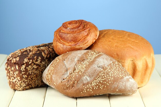 Composition avec pain et petits pains sur table en bois sur fond de couleur