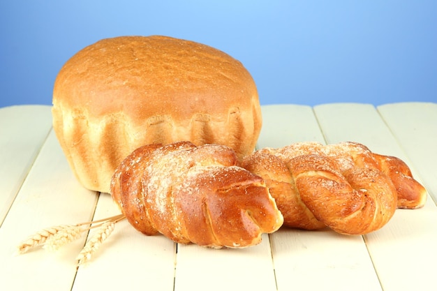 Photo composition avec pain et petits pains sur table en bois sur fond de couleur