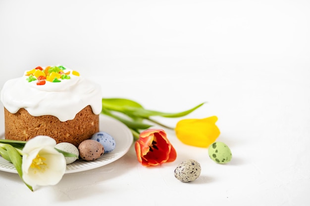 Photo composition de pâques avec gâteau de pâches traditionnel peint œufs de caille et tulipes mise au point sélective