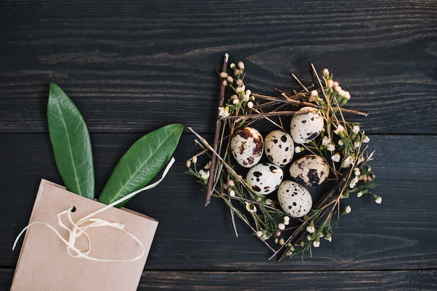 Composition de Pâques avec des œufs, des branches de saule, des oreilles de lapin et des décorations sur fond sombre