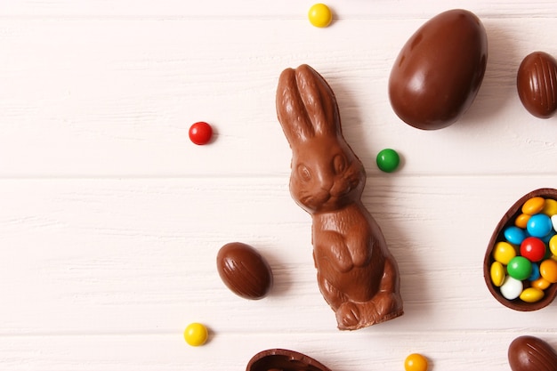 Composition de Pâques avec des oeufs en chocolat et lapin en chocolat sur fond en bois, place pour le texte. bonbons de Pâques. photo de haute qualité