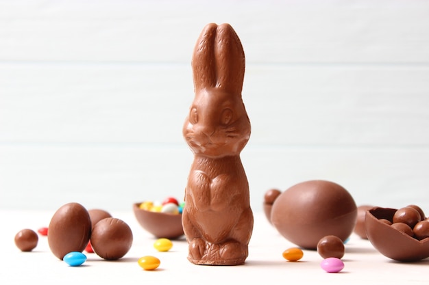 Composition de Pâques avec des oeufs en chocolat et lapin en chocolat sur fond de bois