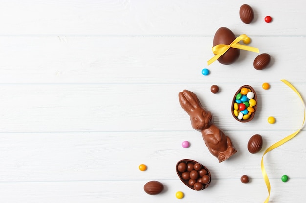 Composition de Pâques avec des oeufs en chocolat et lapin en chocolat sur fond de bois