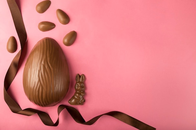 Composition de Pâques avec des oeufs de Pâques au chocolat sur fond rose espace pour le texte