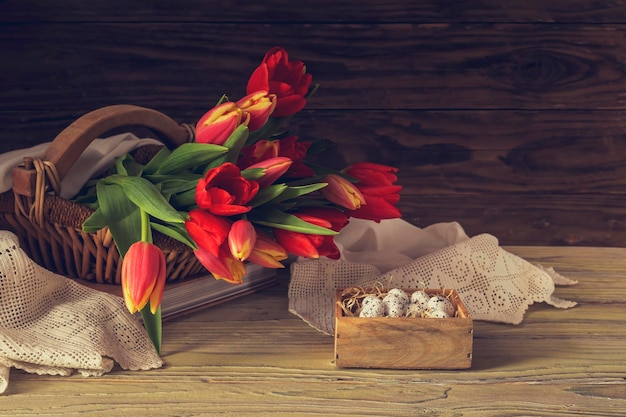 La composition de Pâques Oeufs et tulipes rouges sur fond de bois libre