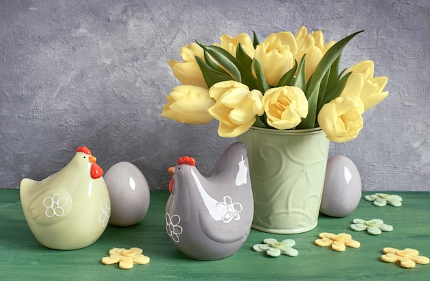 Composition De Pâques Avec Des Tulipes Jaunes Et Des Poules En Céramique Avec Des Oeufs De Pâques En Vert, Jaune Et Gris