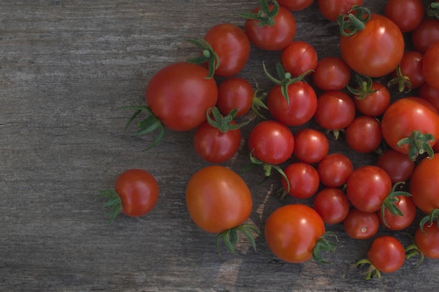 Composition de petites tomates rouges avec un fond en bois pour le texte