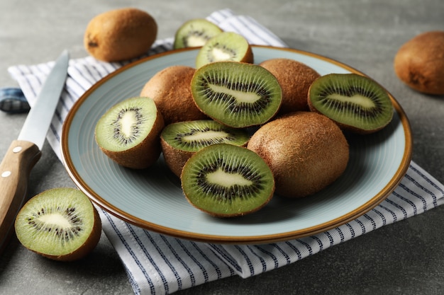 Composition avec plaque de kiwi mûr sur table grise