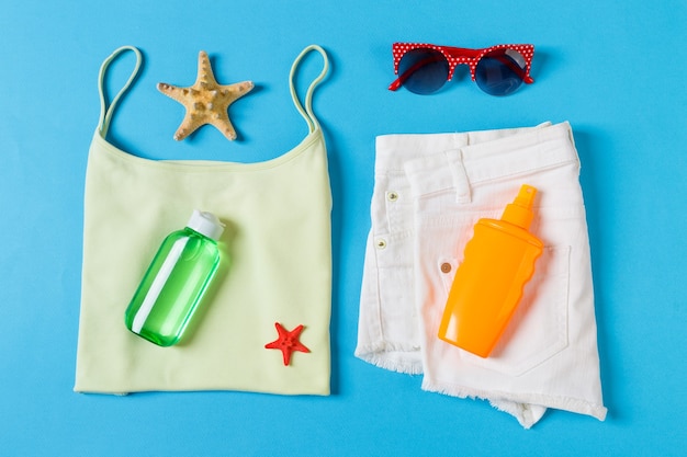 Composition à plat avec accessoires de plage sur fond bleu. Fond de vacances d'été. Vue de dessus des articles de vacances et de voyage.