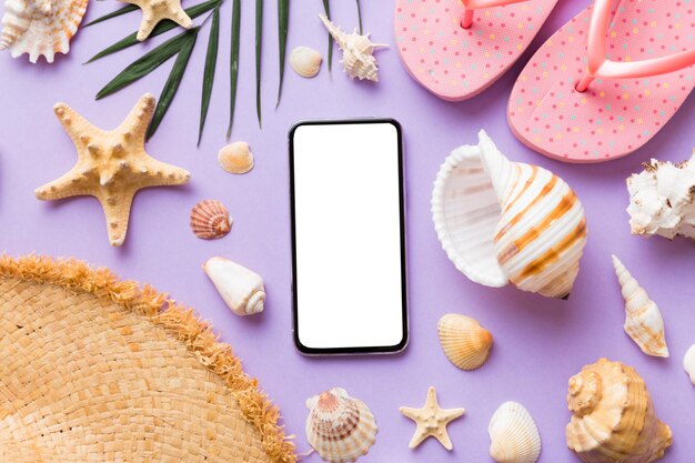 Composition à plat avec accessoires de téléphone et de plage sur fond coloré Smartphone avec écran blanc maquette avec espace de copie