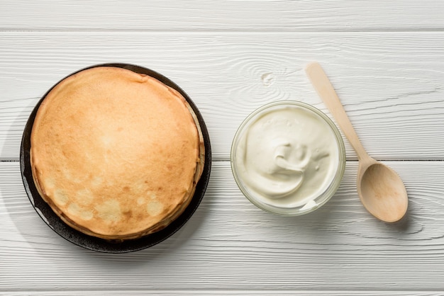 Composition à plat avec une assiette de crêpes et de crème sure