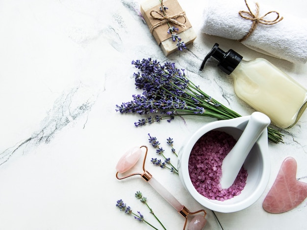 Composition à plat avec des fleurs de lavande et des cosmétiques naturels sur fond de marbre