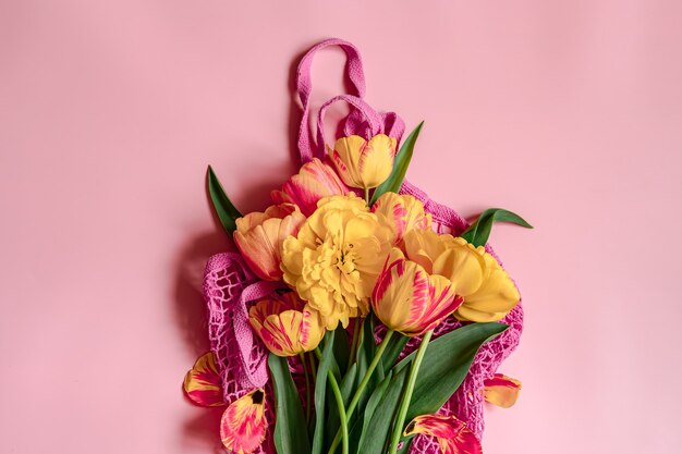 Composition à plat avec des fleurs de printemps sur l'espace de copie du sac à cordes.