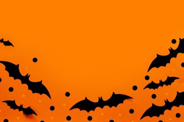 Composition à plat d'Halloween de chauves-souris en papier noir et de citrouilles sur fond orange Concept d'Halloween