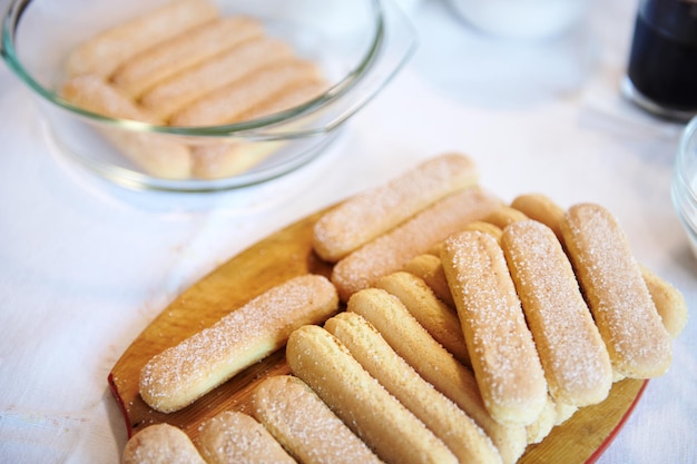 Composition à plat des ingrédients Tiramisu biscuits savoiardi sur une planche de bois Copier l'espace publicitaire