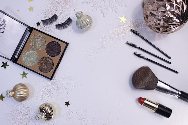 Composition à plat avec produits de maquillage et décoration de Noël sur fond blanc. Modèle de conception, vue de dessus, espace de copie à plat.