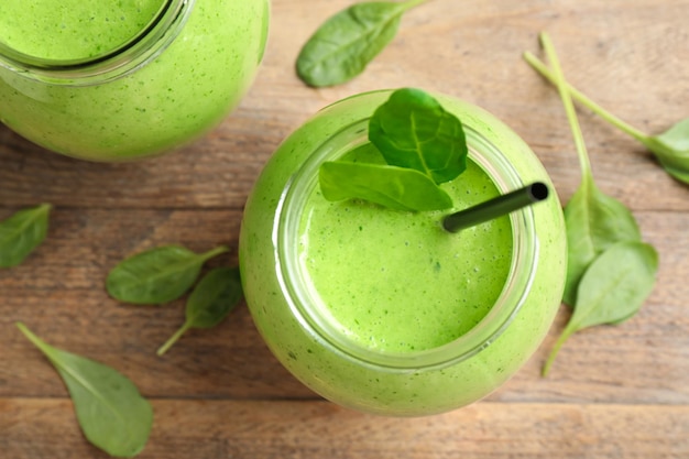 Composition à plat avec smoothie aux épinards sains et verts frais sur table en bois