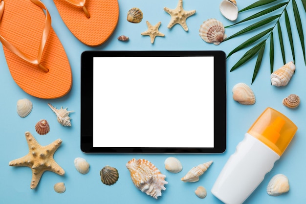 Composition à plat avec tablette et accessoires de plage sur fond coloré Tablette avec écran blanc maquette avec espace de copie