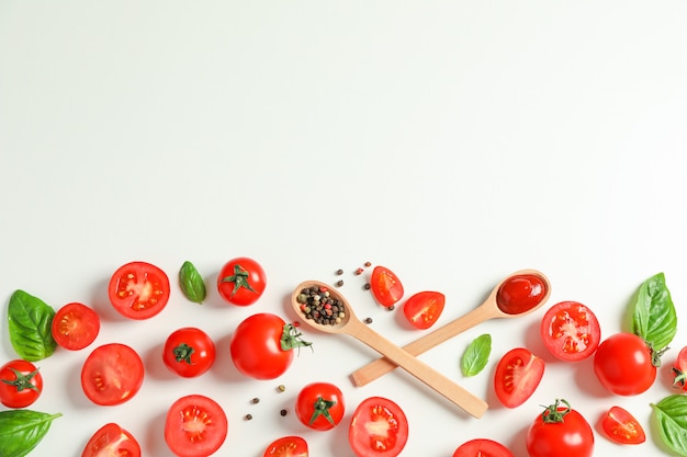 Composition plate avec des tomates fraîches, du poivre, du basilic et des cuillères en bois pour le texte. Légumes mûrs