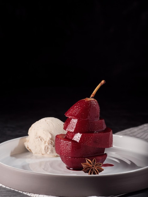 Photo composition avec poires pochées sucrées et crème glacée sur fond clair sombre