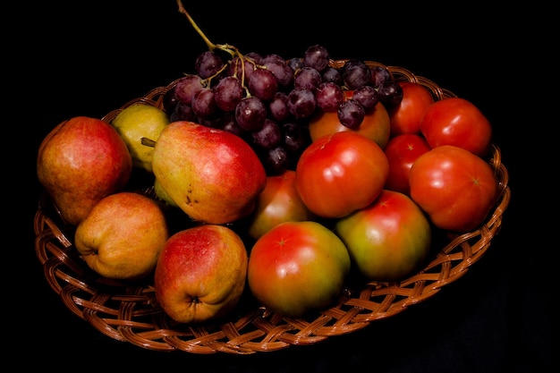 Composition de poires tomates et raisins dans un panier