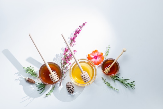 Composition de pots de miel avec des bâtons de miel et des fleurs