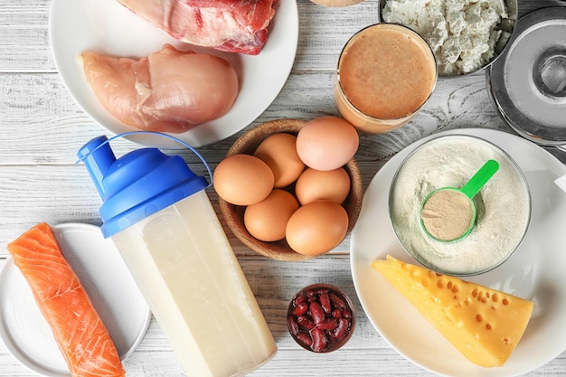 Photo composition avec poudre alimentaire riche en protéines et secouer sur fond de bois