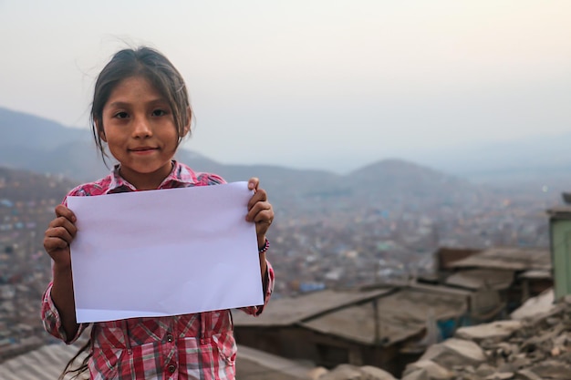 Composition pour la journée des enfants. Fille tenant une feuille de papier vierge pour insérer un texte ou un message