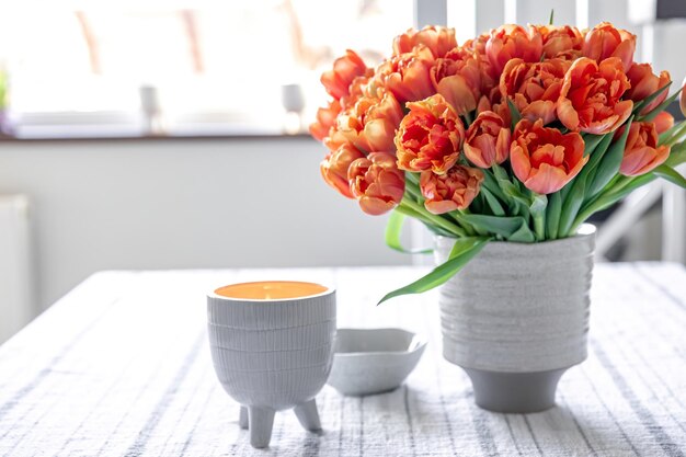 Composition printanière avec un bouquet de tulipes orange à l'intérieur de la maison