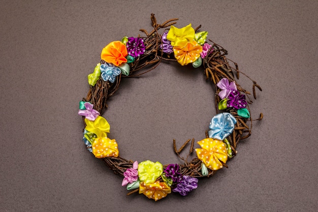 Composition de printemps d'une couronne de branches de bouleau et de fleurs artisanales colorées