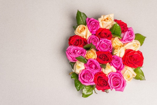 Composition de roses multicolores fraîches sur support en céramique. Le concept festif pour les mariages, les anniversaires, le 8 mars, la fête des mères ou la Saint-Valentin. Carte de voeux, mise à plat, fond de pierre