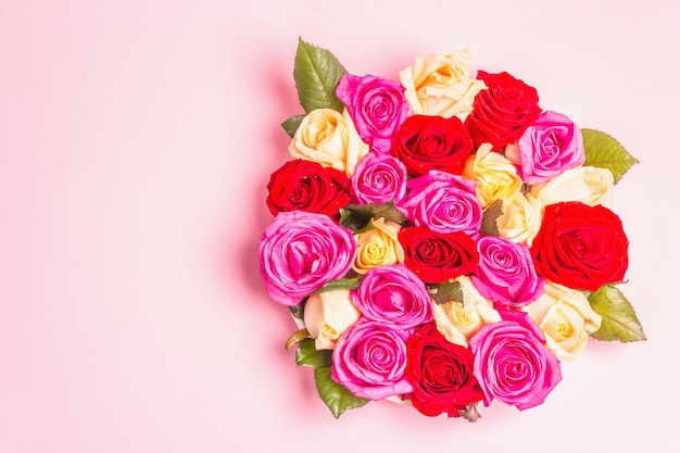 Composition de roses multicolores fraîches sur support en céramique. Le concept festif pour les mariages, les anniversaires, le 8 mars, la fête des mères ou la Saint-Valentin. Carte de voeux, mise à plat, fond rose mat