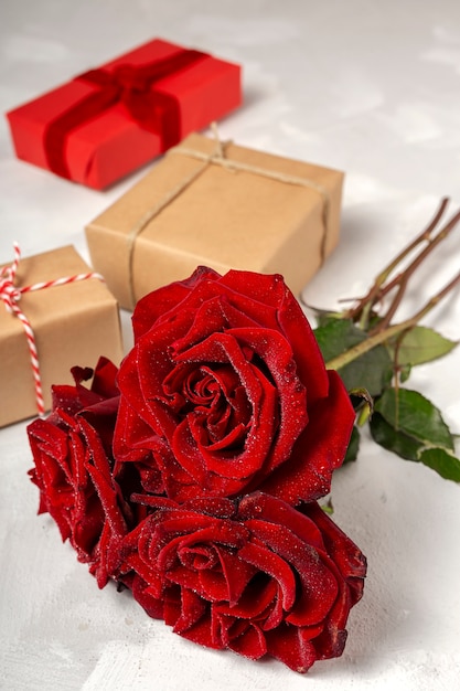 Composition de roses rouges et de coffrets cadeaux