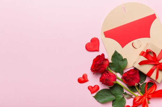 Composition de la saint-valentin avec enveloppe fleur rose et coeur rouge sur la table vue de dessus plat laïcs espace de copie concept de vacances