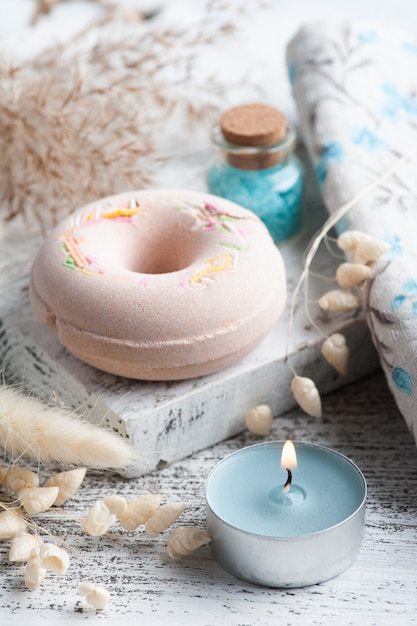 Composition de spa avec beignets de bombe de bain et fleurs sèches sur fond rustique dans un style monochrome. Bougies et sel. Traitement de beauté et détente