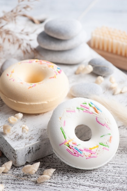 Composition de spa avec beignets de bombe de bain et fleurs sèches sur un mur rustique dans un style monochrome. Bougies et sel. Traitement de beauté et détente