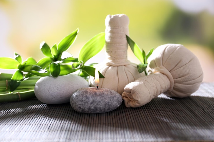 Photo composition de spa avec bougie de sacs de massage aux herbes et bambou sur table sur fond naturel