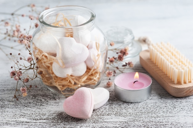 Composition de spa avec des coeurs de bombe de bain et des fleurs sèches sur fond rustique dans un style monochrome. Bougies et sel. Traitement de beauté et détente