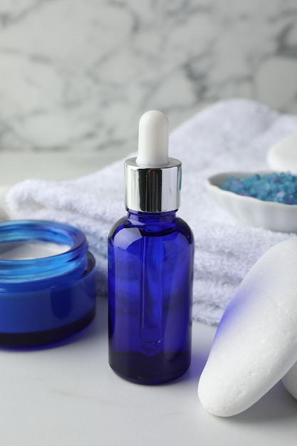Composition de spa Produits cosmétiques serviette de sel de mer et pierre sur table blanche