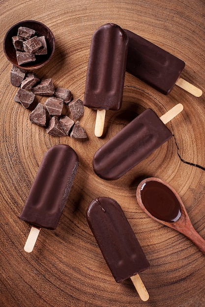 Photo composition avec des sucettes glacées au chocolat sur fond en bois. vue de dessus