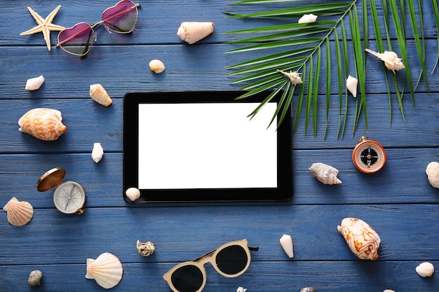 Photo composition avec tablette sur fond de bois concept de vacances d'été